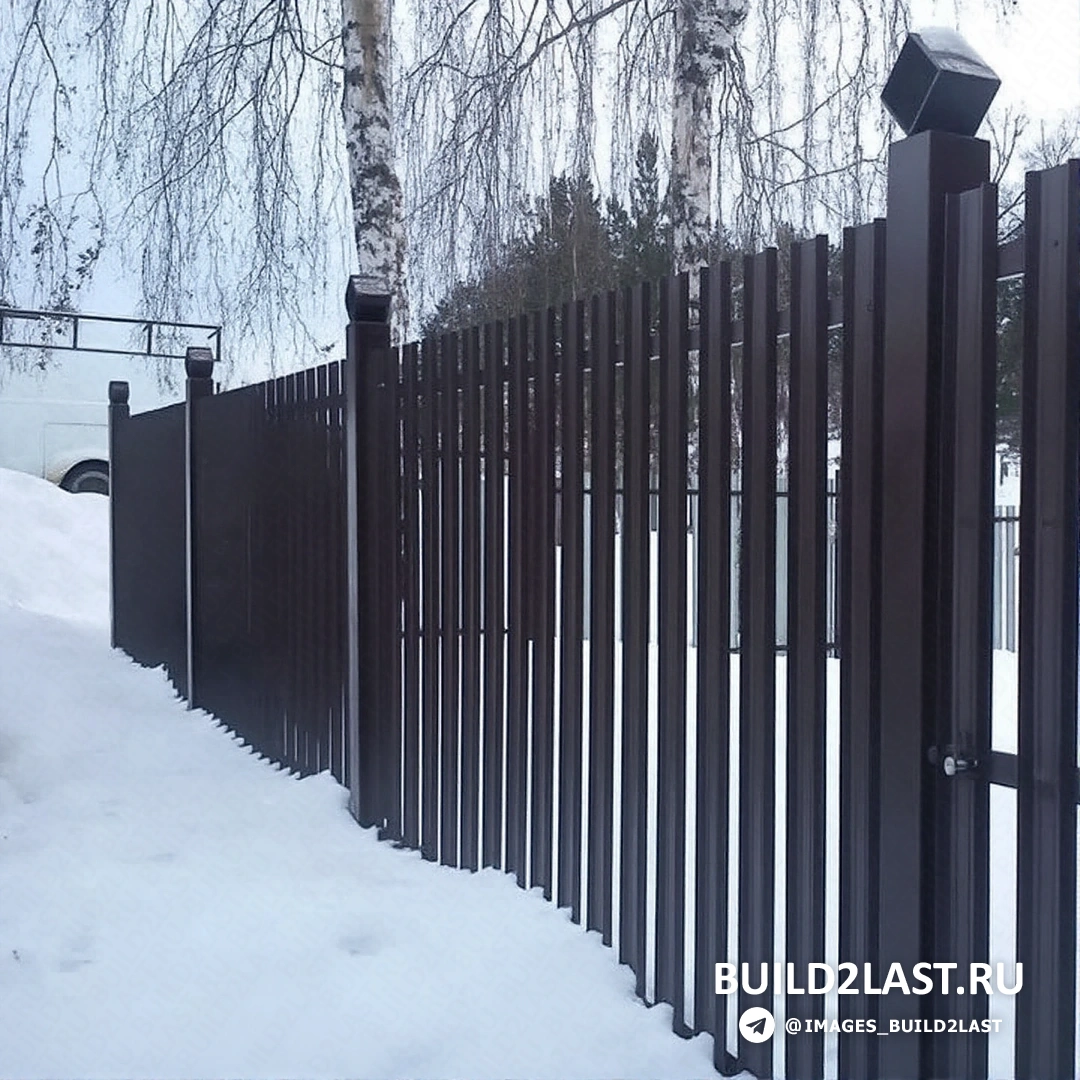 Забор из металлического штакетника с кирпичной отделкой в коричневых тонах